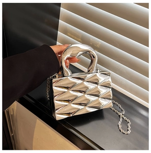 Detail of silver metallic box bag with quilted texture and rigid round handle
