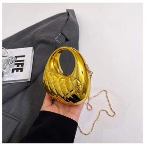 Detail der goldenen Metallic-Schalentasche mit Steppmuster und feiner Kugelketten-Gurt