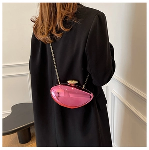 Metallic pink crossbody bag with gold chain shown on a woman in a black blazer