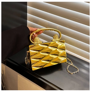 Detail of golden box bag with lion head ring handle and quilted texture metal finish