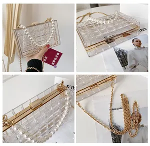 Détail du sac quadrillé en acrylique transparent avec poignée perle et cadre doré