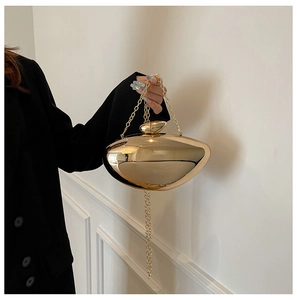 Detail shot of the irregular streamlined gold metallic evening bag with chain strap