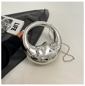 Detail of silver metallic crescent handbag with embossed star pattern and chain strap