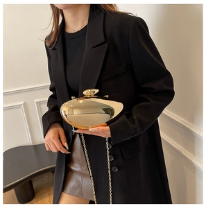 Chic gold metallic evening clutch bag with unique lock and elegant chain strap detail