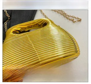 Macro shot of gold evening clutch featuring horizontal ribbed texture and chain strap