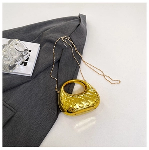 Detail einer goldenen sichelförmigen Muscheltasche mit eleganter Rautensteppung