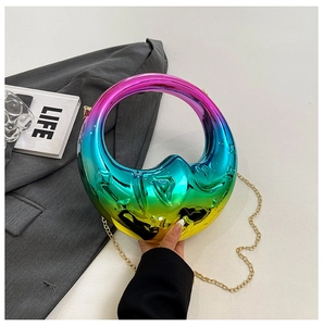 Macro shot of circular rainbow gradient evening bag with metallic sheen and gold chain