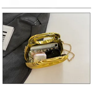 Detail view of the golden shell evening bag capacity with phone and sunglasses