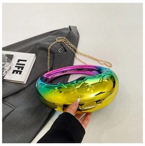 Detailed shot of moon-shaped handbag featuring rainbow gradient finish and gold chain