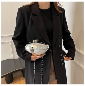 Close-up of a silver pebble-shaped clutch bag with polished metallic surface and chain
