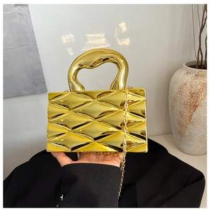 Detailed view of a gold metallic box bag with textured diamond pattern and chain strap