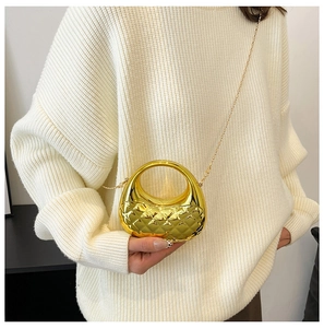 Detail einer goldenen gesteppten Muscheltasche mit Rundgriff und Perlenkettenriemen