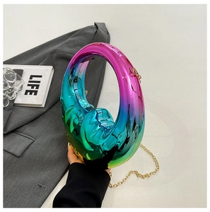 Close-up of gradient metallic evening bag with moon handle and gold chain strap