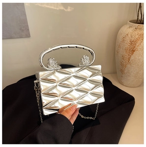 Macro view of silver geometric clutch with lion head handles and chain strap