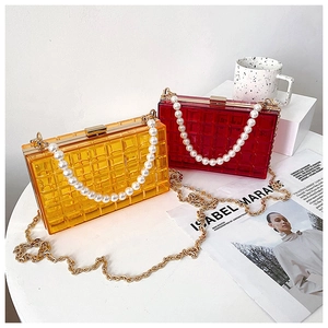 Détail de pochettes en acrylique avec poignées en perles et texture quadrillée