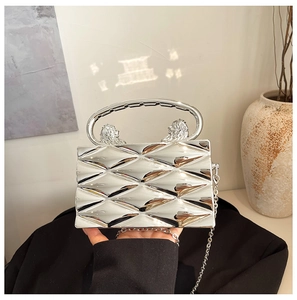 Detail of silver mirror box bag with 3D diamond pattern and lion head metal handles