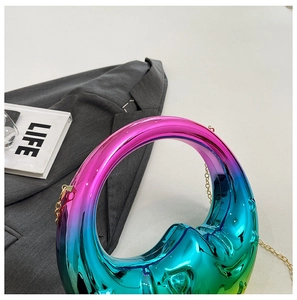 Macro detail of crescent moon evening bag with gradient metallic finish and gold chain
