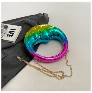 Detail of moon-shaped evening bag with rainbow gradient finish and gold chain strap