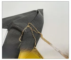 Détail de la chaîne dorée raffinée sur un sac à main en acrylique jaune translucide