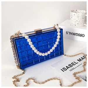 Détail de la pochette bleue en acrylique avec anse en perles et texture matelassée