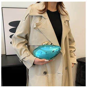 Close-up of a glossy peacock blue shell-shaped evening bag with a golden metal clasp