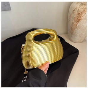 Macro shot of gold metallic wave texture on a structured evening clutch bag with chain
