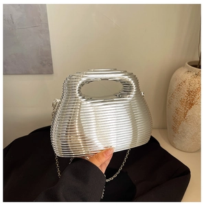 Close-up of a silver hard-shell evening bag with horizontal layers and chain strap