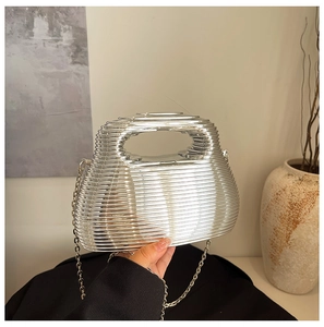 Detail of silver wavy evening bag featuring metallic texture and elegant chain strap