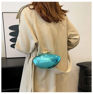Detail of teal metallic pebble clutch with gold chain on a trench coat model