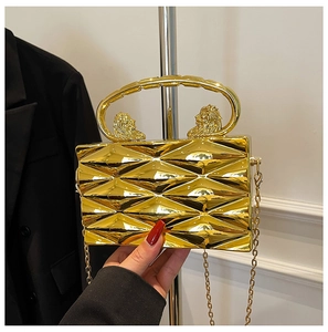 Detail of golden geometric evening bag featuring lion head handles and metallic texture