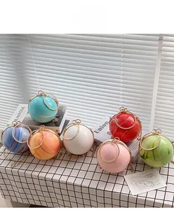 Group display of round evening clutch bags in multiple colors with gold handles