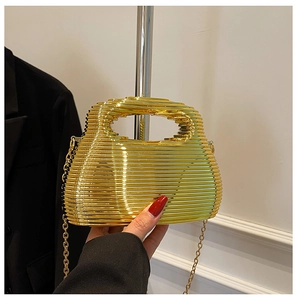 Detail of gold metal evening bag with layered wave texture and slim chain strap