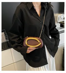 Detailansicht der dunkelrotbraunen Leder-Abendtasche mit großer goldener C-Metallschließe
