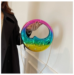 Detail of crescent moon handbag with iridescent gradient finish and gold metal chain strap