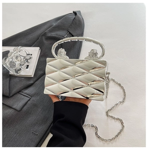 Silver metallic box clutch featuring quilted pattern and ornate lion head handle details