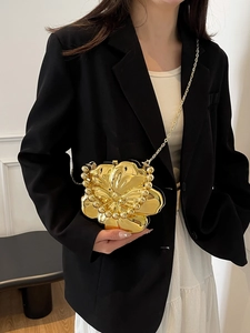 Detailed view of a gold flower evening bag with layered petals and beaded edges