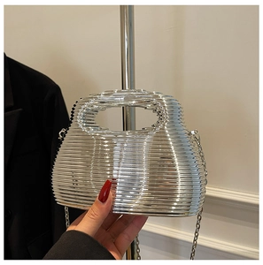 Close-up of silver rippled metal cage evening bag with luxury chain strap detail