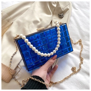 Détail du sac de soirée en acrylique bleu saphir avec anse en perles et chaîne dorée