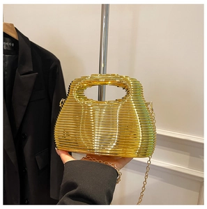 Detailed view of golden ripple evening clutch featuring horizontal metal hollow framework