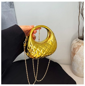 Detail einer goldenen Metallic-Tasche mit Steppmuster und runder Perlenkette