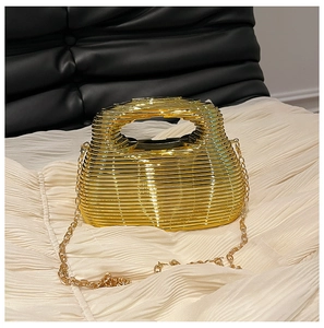 Detail of gold metal evening bag with horizontal bars on pleated cream fabric