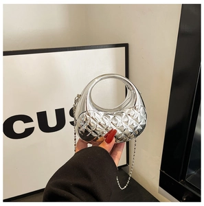 Nahaufnahme einer silbernen Metallic-Tasche mit rundem Griff und Steppmuster-Detail