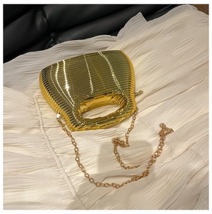 Detailed macro view of glossy gold textured evening bag with sleek chain strap