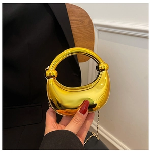 Nahaufnahme einer metallisch goldenen Mondsichel-Tasche mit Glanzeffekt und feiner Kette