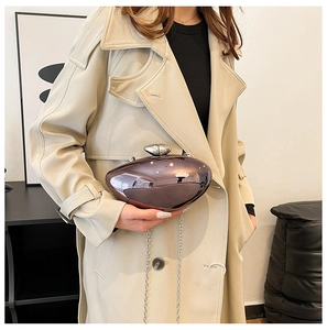 Detail of purple metallic crossbody bag with silver acrylic chain on a trench coat