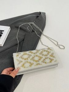 Macro view of silver evening clutch featuring intricate pearl beadwork and metal chain strap