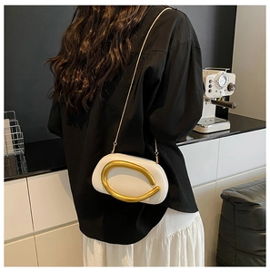 Detail der weißen matten Leder-Abendtasche mit großem Goldring und Kettenriemen
