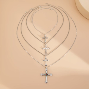 Vue détaillée de quatre colliers croix argentés avec accents de cœur et pierres précieuses