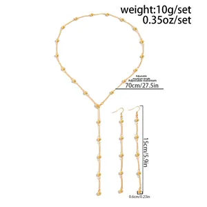 Detail view of golden bead chain necklace and long tassel earrings with measurements