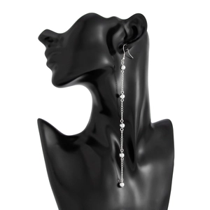 Detail of silver long tassel earrings with metal beads shown on a black portrait model
